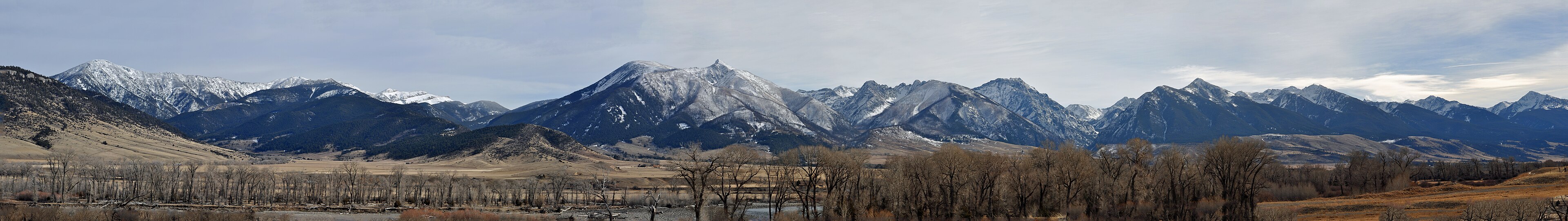 Panoramic view of the snow-dusted Absaroka Range rising above a river valley